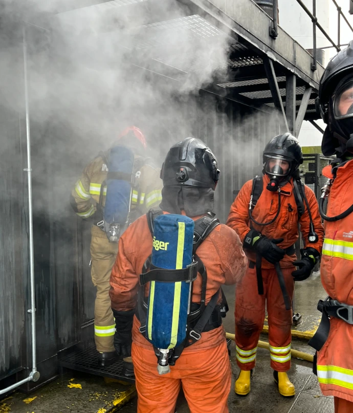 Hans komt de container uit na een brandoefening in de hitte en het donker